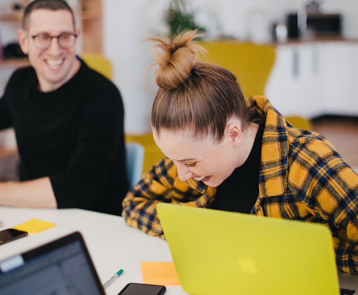Une femme en train de rire avec son collègue