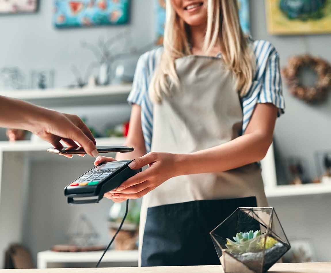 Une fleuriste tend un appareil bancaire à son client