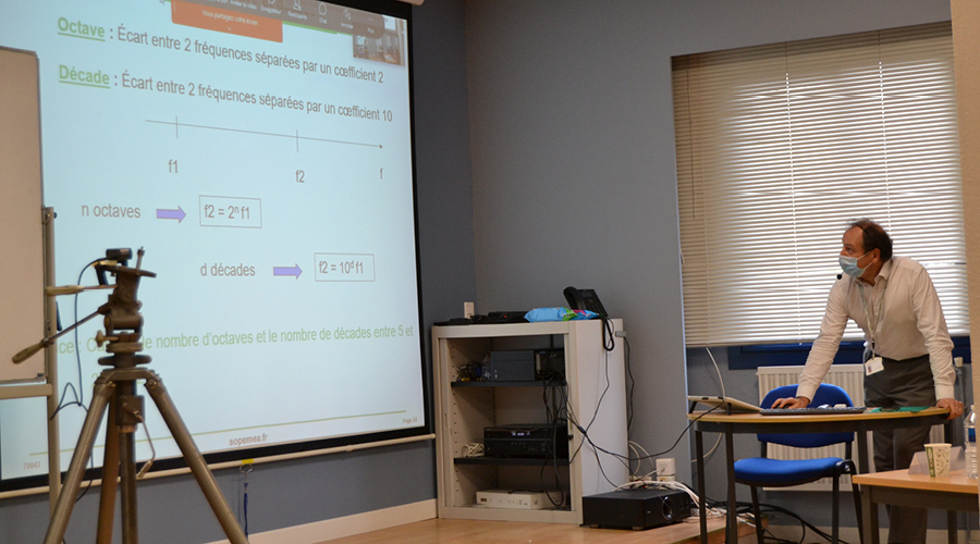 Un homme projette un cours en ligne sur un écran géant